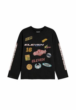 Chemise noire à manches longues avec plusieurs patchs imprimés colorés et logos, y compris "ELEVEN," "16," et "ELVN" à l'avant et sur les manches.