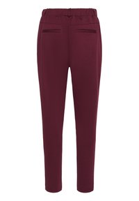 Pantalons bordeaux à taille élastique avec une coupe slim. Comprend deux poches discrètes et une texture lisse. Pas de matériel visible ni d'embellissements.