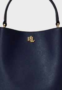 Bolsa de pele azul marinho com um design estruturado, apresentando um logo dourado "RL" e uma superfície texturizada e suave. Alças curtas com detalhes em dourado.
