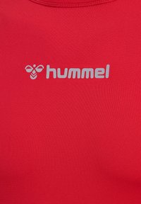 Rood sportshirt gemaakt van glad, rekbaar materiaal; heeft een zilveren logo "hummel" prominent op de voorkant gedrukt.