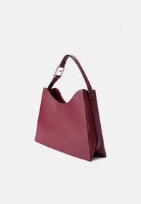 Borsa in pelle bordeaux con forma strutturata, caratterizzata da un orlo superiore ondulato e una fibbia dorata sulla tracolla regolabile. Texture liscia.