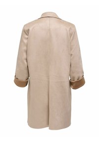 Cappotto beige in tessuto morbido con una finitura leggermente testurizzata. Presenta un'apertura sul retro e polsini arrotolati marroni, colletto su misura e taglio dritto.