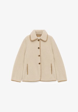 Fleecejacke in Creme mit braunen Akzenten, mit Kragen, Knopfverschluss und zwei seitlichen Taschen. Weicher Stoff und entspannter Schnitt.