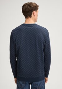 Felpa blu navy con motivo esagonale, collo a giro, polsini a coste, realizzata in tessuto morbido con una finitura testurizzata.