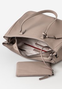 Hellgraue Leder-Umhängetasche mit zwei Griffen, die geöffnet ist und ein gemustertes Innenfutter sowie eine passende Reißverschlusstasche zeigt. Mit einer roten Akzenttasche.