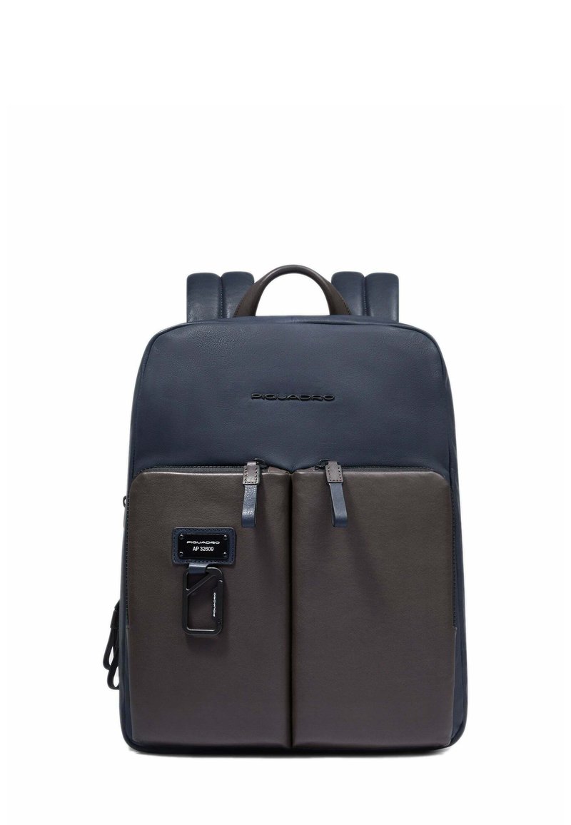 Mochila sintética en azul marino y gris con textura suave, dos bolsillos frontales, tirantes ajustables y asa superior. Diseño minimalista.