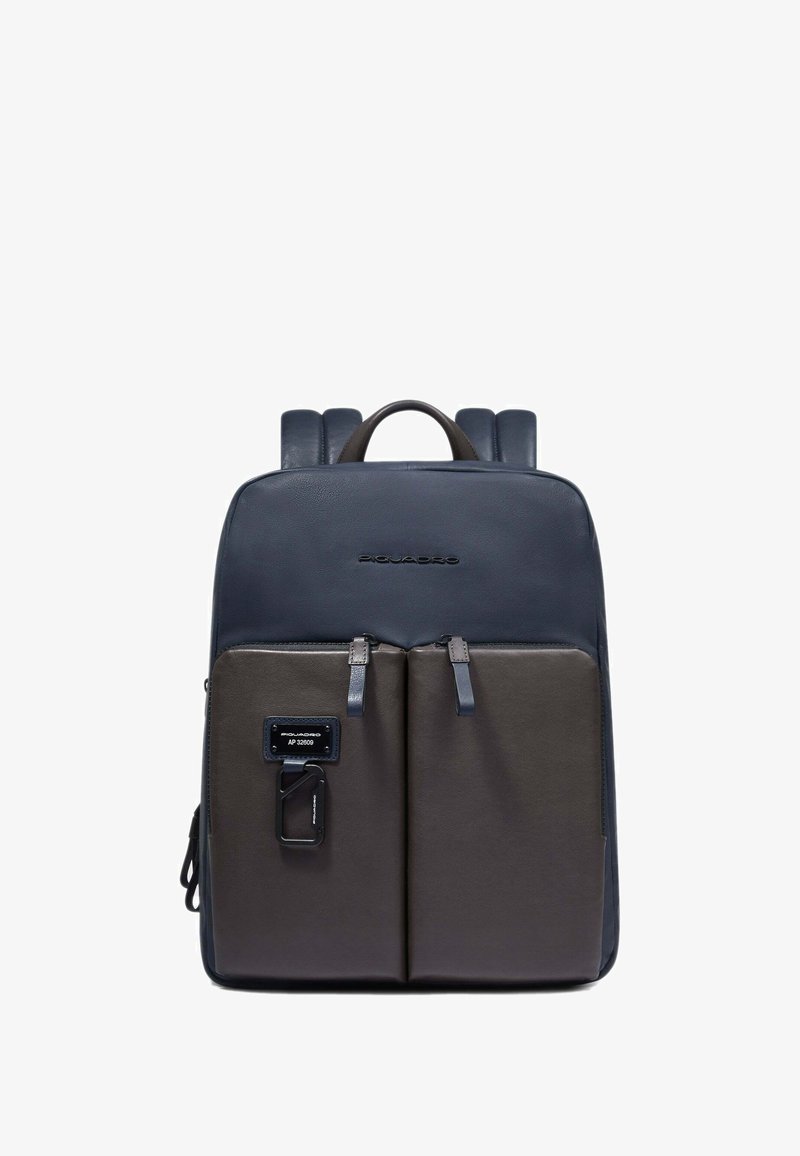 Mochila sintética en azul marino y gris con textura suave, dos bolsillos frontales, tirantes ajustables y asa superior. Diseño minimalista.