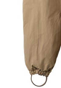 Tan, lightweight pant leg with elastic cuff and loop detail. Features smooth texture and clean stitching along the side seam.