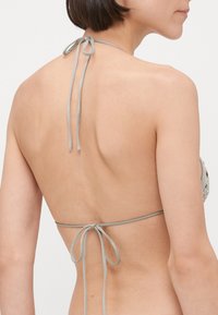 Light gray bikini top with halter neck and back ties, featuring decorative beads on the front panel. Smooth fabric texture.