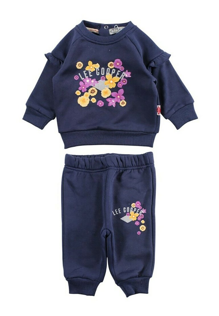 Ensemble de survêtement en coton bleu marine avec broderie florale. Le pull a des manches à volants ; le pantalon possède une taille élastique et un motif floral similaire.