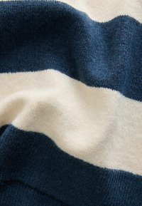 Triibuline kudum sinise ja kreemja värviga, pehme tekstuuriga ning vahelduvate horisontaalsete ribaelementidega, keskmise paksusega.