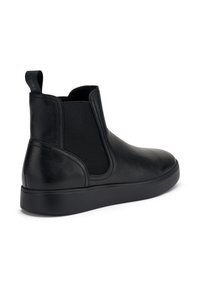 Stivali Chelsea in pelle nera con pannelli laterali elastici, un tab di estrazione e una suola in gomma nera texture. Finitura liscia con dettagli di cucitura minimi.