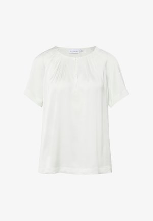 Weiße Bluse mit kurzen Ärmeln, rundem Ausschnitt, dezenten Falten vorne und einem kleinen Schlitzdetail vorne.