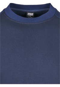 Marineblauwe trui gemaakt van zacht materiaal met een klassieke ronde hals en geribbelde accenten bij de kraag, met een gladde, egale textuur.