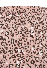 Leopard print fabric in pink with black and beige spots, featuring elastic waistband and visible side pockets. Soft, textured material.