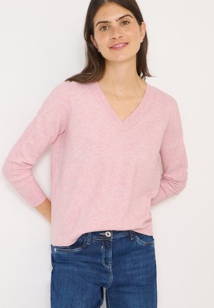 Rosa V-Ausschnitt-Pullover mit langen Ärmeln, strukturiertem Strick, lockerer Passform, kombiniert mit dunkelblauen Denim-Jeans. Einfaches Design, keine bemerkenswerten Akzente.