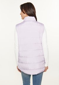 Jachetă puf lavender cu guler înalt, cusături orizontale și un tiv ușor curbat, purtată peste o cămașă albă cu mâneci lungi.