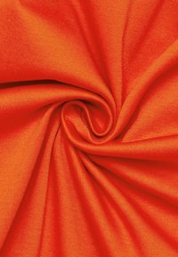 Tessuto arancione brillante con una consistenza liscia e morbida, disposto a spirale, che mette in mostra il suo colore vivace e la trama uniforme.