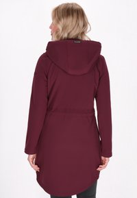 Bordeaux lange jas met capuchon, smal toelopende taille en ronde zoom. Gemaakt van gladde stof, met lange mouwen en een minimalistisch ontwerp.