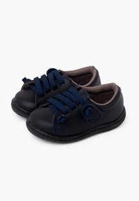Scarpe in pelle blu navy con punta tonda, lacci in tessuto, rivestimento interno morbido e suole in gomma. Presentano cuciture blu e un piccolo dettaglio con logo.