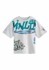 Weißes, übergroßes T-Shirt aus Baumwolle, mit bunten Graffiti-ähnlichen Drucken in Türkis, Pink und Schwarz, die sich über die Vorderseite und die Ärmeln erstrecken.