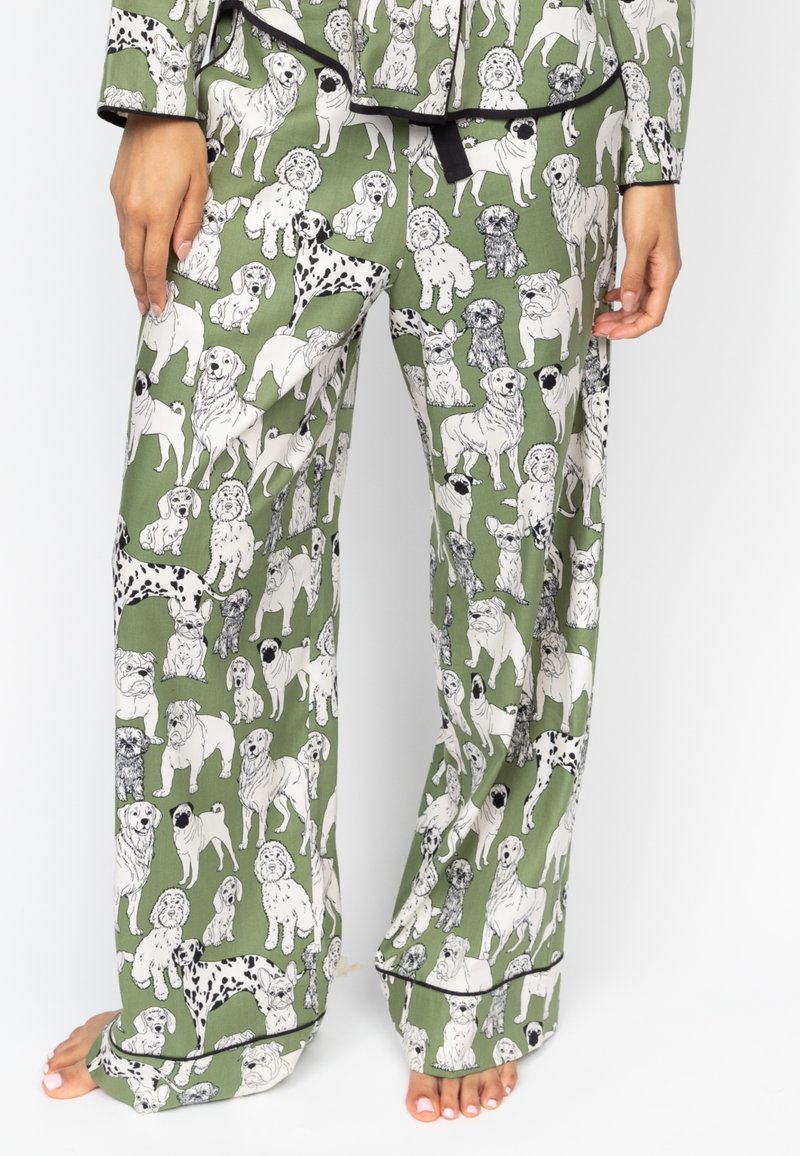 Groene pyjamabroek met een full-color print van verschillende hondenrassen in zwart en wit. Zachte stof, wijde pijpen en contrasterende bies.
