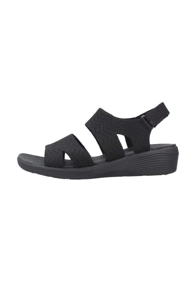 Sandalia negra con un diseño de tira trenzada, punta abierta y una suela de plataforma acolchada. Correa trasera ajustable para un ajuste seguro.