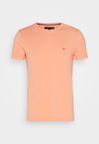 T-shirt a maniche corte di colore pesca chiaro, realizzato in morbido tessuto di cotone. Presenta un piccolo logo sul lato sinistro del petto e un colletto girocollo.