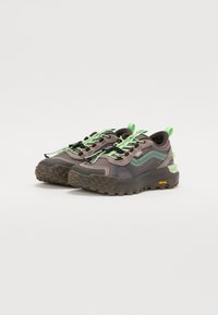 Brown and green sneakers with mesh panels, textured rubber sole, and vibrant green laces and accents. Features a rear pull tab and logo.