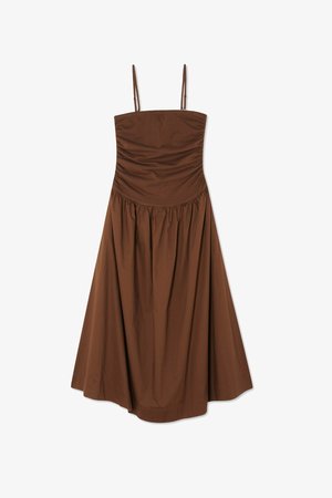 Brūns, bez piedurknēm, kleita ar pieguļošu augšu un savilktu svārku. Izgatavota no gludas auduma, ar regulējamām siksnām un kleitas garumu līdz ceļiem.