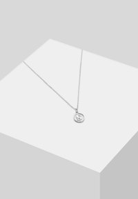 Strieborný náhrdelník so zaobleným príveskom s vyrazeným písmom "S", visiaci na jemnom reťazci. Jednoduchý a minimalistický dizajn.