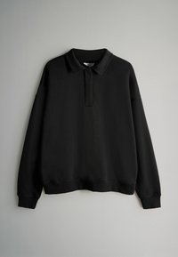 Zwarte sweatvest met een kraag, verlaagde schouders en geribbelde manchetten. Zachte stof met een gladde textuur en een relaxed fit.