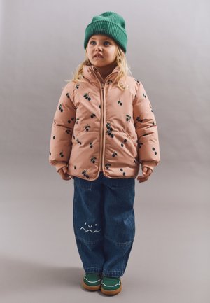 Jachetă roz căptușită cu modele de frunze verzi, asortată cu pantaloni din denim albaștri și o căciulă verde. Pantofi verzi cu talpă maro, detalii jucăușe pe pantaloni.