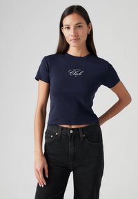 T-shirt cropped azul marinho em tecido de algodão com mangas curtas e decote redondo, com texto branco que diz "Join the Club."