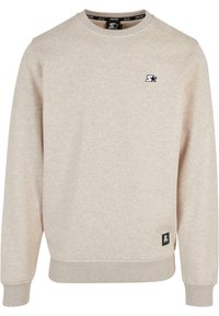 Sweat-shirt beige à col ras du cou avec poignets et ourlet côtelés, présentant de petits logos d'étoiles noires sur la poitrine et le bas devant.