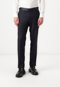Námornícke sako nohavice s hladkou textúrou, slim fit a saténovým pásom. Nosené s čiernymi koženými topánkami s lesklým povrchom.