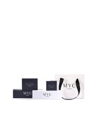 Drie rechthoekige cadeaudozen in donkerblauw en wit, gelabeled "MYC PARIS," vergezeld van een witte boodschappentas met zwarte handvatten.
