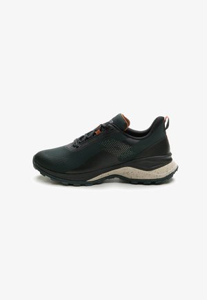 Black athletic shoe with a breathable mesh upper, textured panel, and speckled beige rubber sole. Features reinforced heel and contrasting accents.