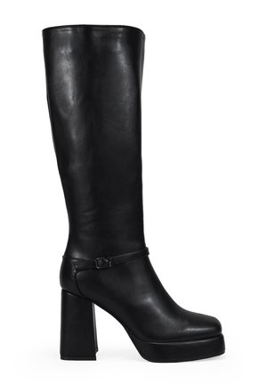 Bota negra hasta la rodilla hecha de cuero suave, con un chunky tacón alto, plataforma en la parte delantera y una delgada correa en el tobillo con un detalle de hebilla.