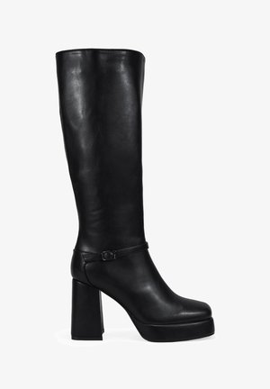 Bota negra hasta la rodilla hecha de cuero suave, con un chunky tacón alto, plataforma en la parte delantera y una delgada correa en el tobillo con un detalle de hebilla.