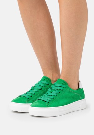 Sneakers in suede verde con suola e lacci in gomma bianca, caratterizzati da una texture liscia e un design minimalista. Accenti bianchi sul tallone.
