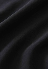 Schwarze Stoffoberfläche mit einer glatten, weichen Textur und subtiler glänzender Oberfläche. Enthält weich fließende Linien und sanfte Drapierung.