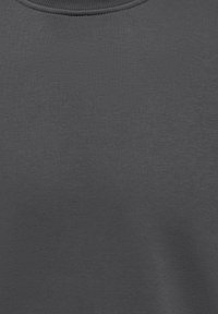 Tamsiai pilkas džemperio audinys su išaustu tekstūruotu raštu, apvaliu iškirpimu ir minimalistiniu siūlių dekoravimu aplink apykaklę.