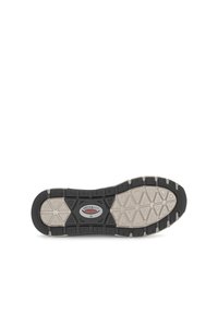 Semelle de chaussure en caoutchouc noir avec une semelle intermédiaire blanche texturée, présentant un motif géométrique et un logo rouge central portant la mention "rolling soft".