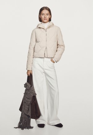 Light beige quilted puffer jacket with a hood, silver zipper, and side pockets. Paired with wide-leg white pants and a brown bag with a gray scarf.