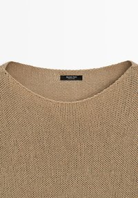 Maglione beige in maglia con scollo rotondo e etichetta del marchio Massimo Dutti cucita all'interno del colletto.