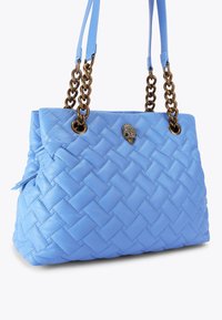 Borsa a mano in pelle intrecciata blu con design trapuntato. Presenta catene metalliche marroni e un emblema decorativo sul davanti.
