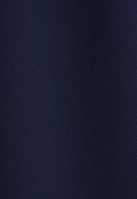 Tessuto blu navy testurizzato con un motivo sottile, che presenta un aspetto morbido e intrecciato. Il materiale suggerisce durata e versatilità.
