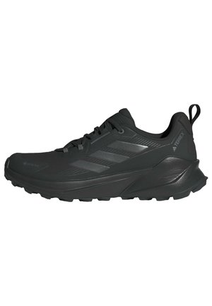 Pánská černá běžecká bota Adidas Terrex s tkaničkami, texturovanou podrážkou, logem Gore-Tex a poutkem na patě, boční pohled.