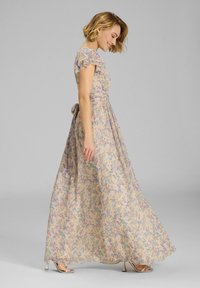 Maxikleid aus leichtem, floral gemustertem Stoff mit kurzen Rüschenärmeln, tailliertem Design und seitlichem Bindeband. Farben umfassen pastellgelb, blau und pink.